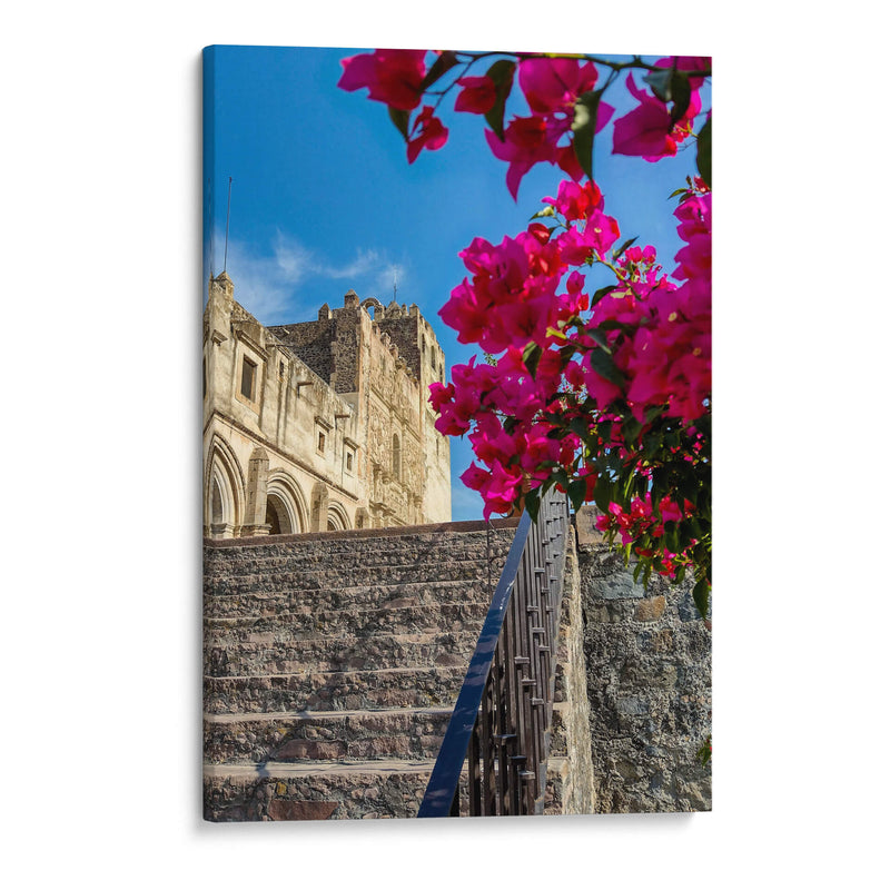 Histórico Monasterio de Yuriria enmarcado por vibrantes bugambilias bajo un cielo azul despejado. - Nosion | Cuadro decorativo de Canvas Lab