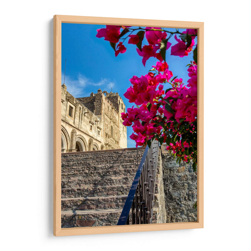 Histórico Monasterio de Yuriria enmarcado por vibrantes bugambilias bajo un cielo azul despejado. - Nosion | Cuadro decorativo de Canvas Lab
